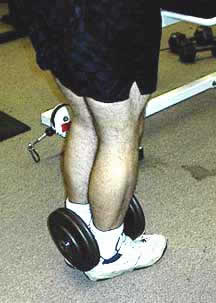 Holding a dumbbell between the feet for chin-ups